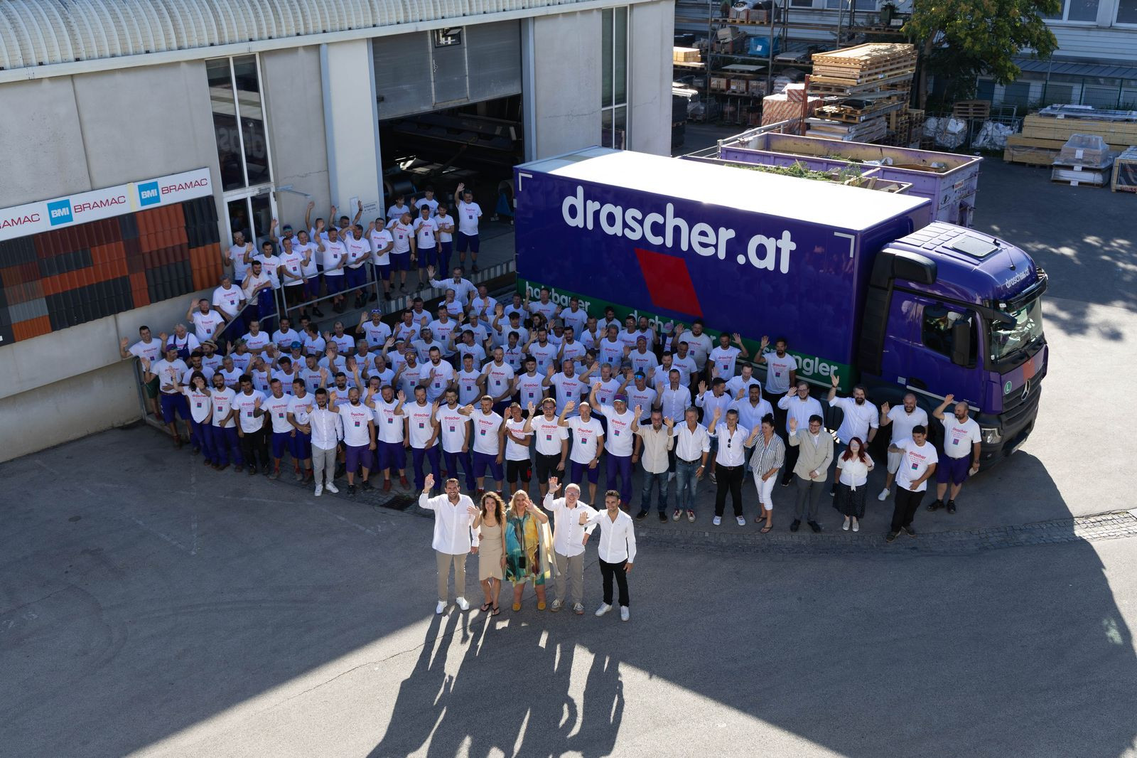 Das gesamte Team vor dem violetten Firmen-LKW